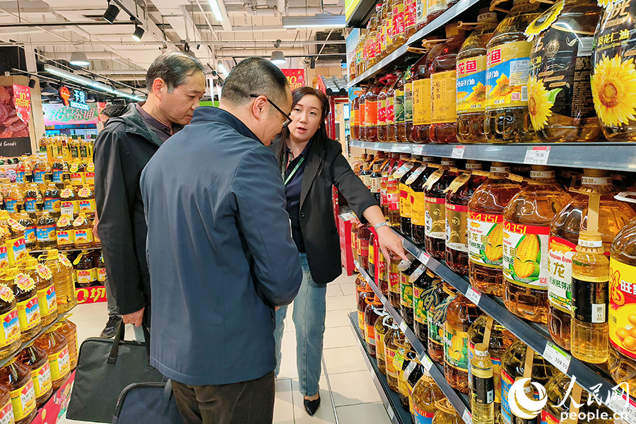 調研檢查組在超市食油專櫃了解商品價格、品質等情況。陳遴攝