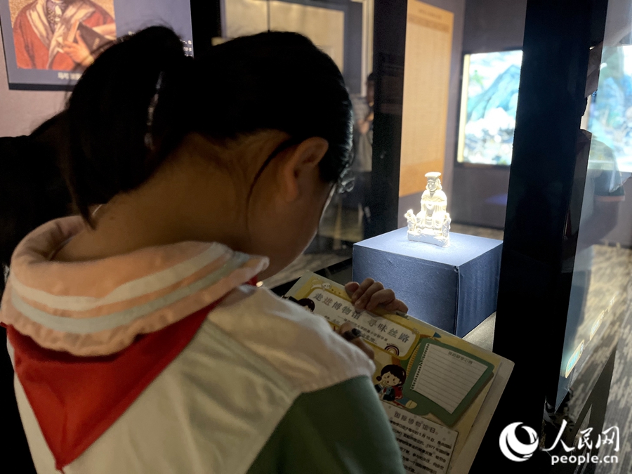 穿越古今，孩子们用笔记录德化窑白釉妈祖坐像。人民网 钱嘉禾摄