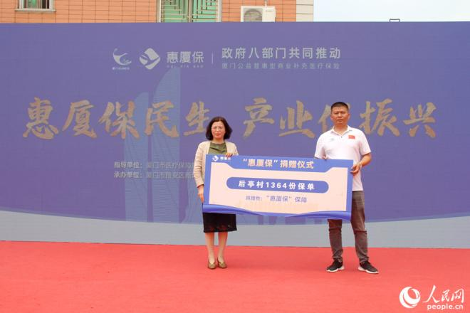 “惠厦保”项目组代表向后亭村1364名村民捐赠爱心保单。人民网 陈博摄