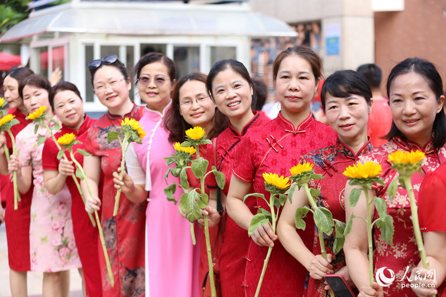 4.廈門雙十中學考生家長們身穿旗袍，手拿向日葵在考場外為孩子加油打氣，寓意“旗開得勝，一舉奪魁”。人民網記者 陳博攝