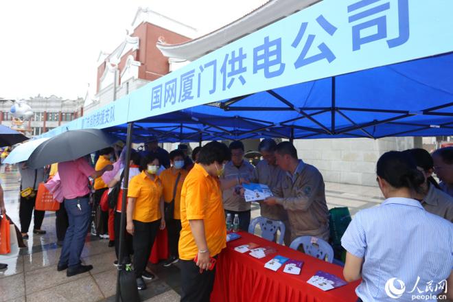 各成员单位印制行业安全常识宣传品向观众发放。人民网 陈博摄