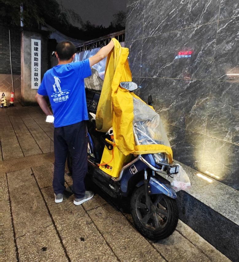 吳師傅洗好空調返回路上下起雨。黃東儀攝