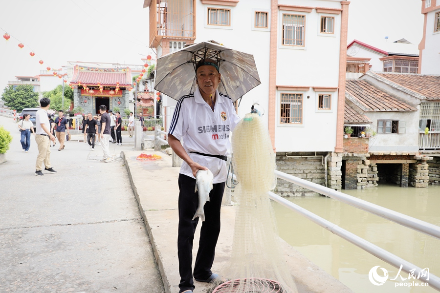 豆巷村的村民用渔网捕上了一条大鱼。人民网 谢小姿摄