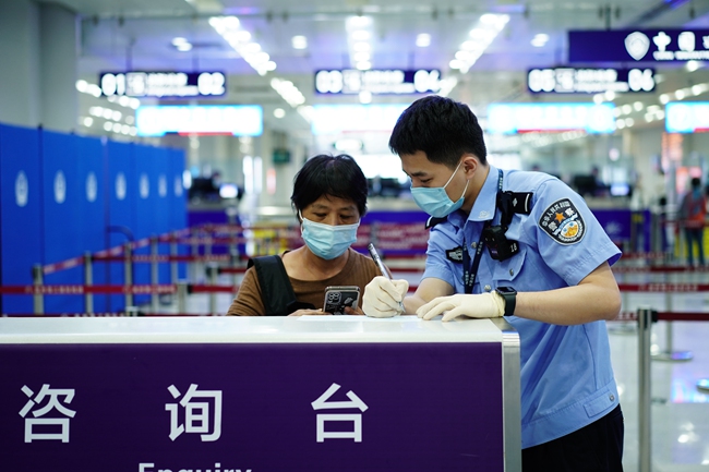 民警解答旅客出入境相关问题。
