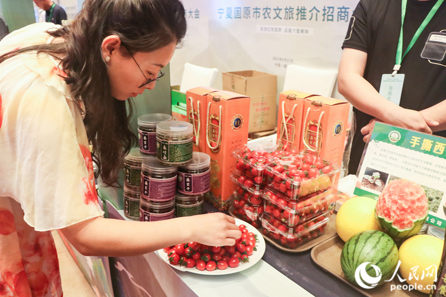 游客正在品尝来自固原的新鲜小番茄。人民网 钱嘉禾摄