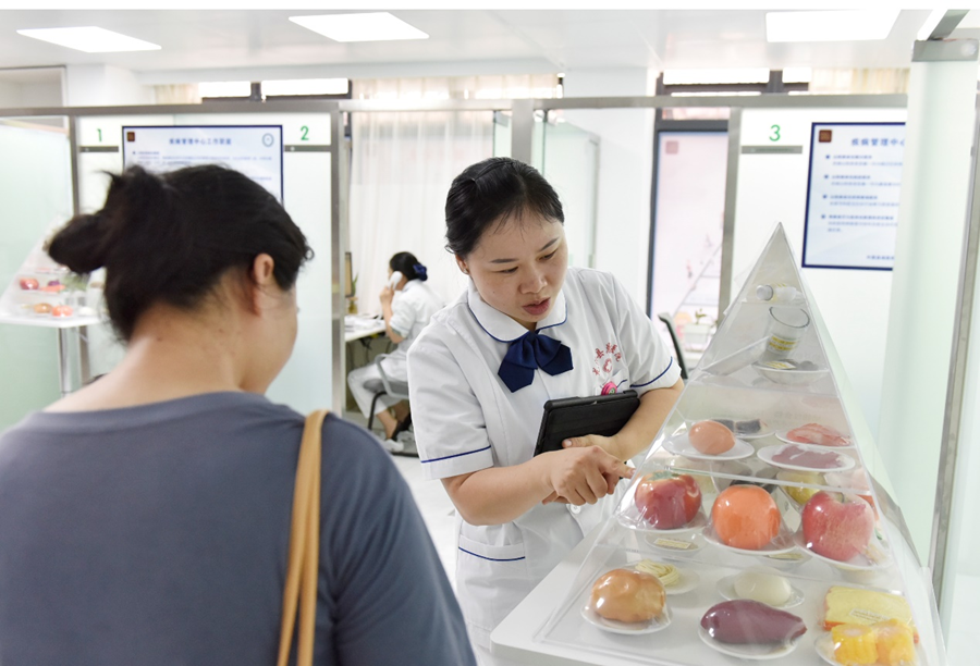 疾病管理师张秀春为群众讲解健康饮食知识。罗姮摄