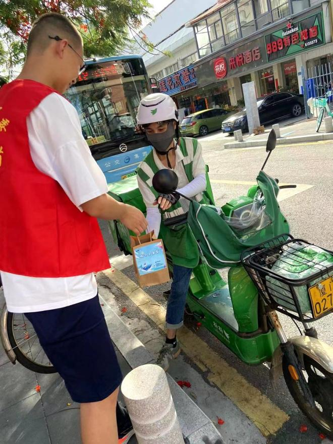 “城市小当家”志愿者为快递人员送上清凉饮品。思明区融媒体中心供图