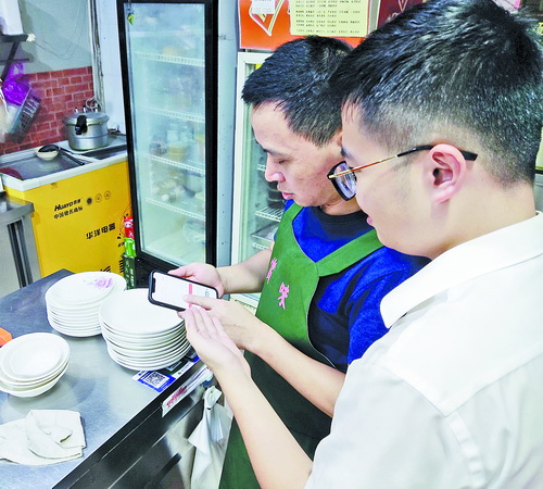 台风过后，厦门工行工作人员主动走访商户、企业，手把手协助使用手机银行线上办理业务，把便民金融服务送到“家门口”。