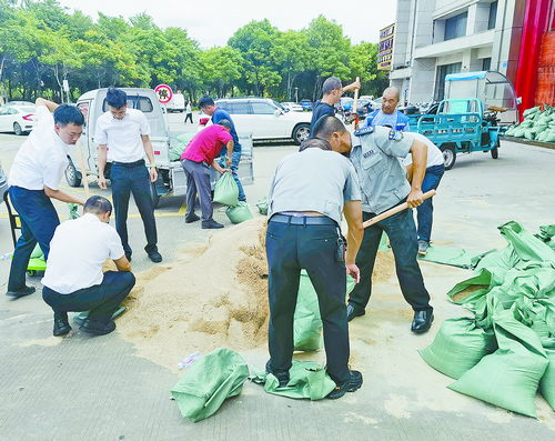 　厦门工行工业集中区支行工作人员协助周边小区物业摆放沙包、沙袋，加强小区安全防护。