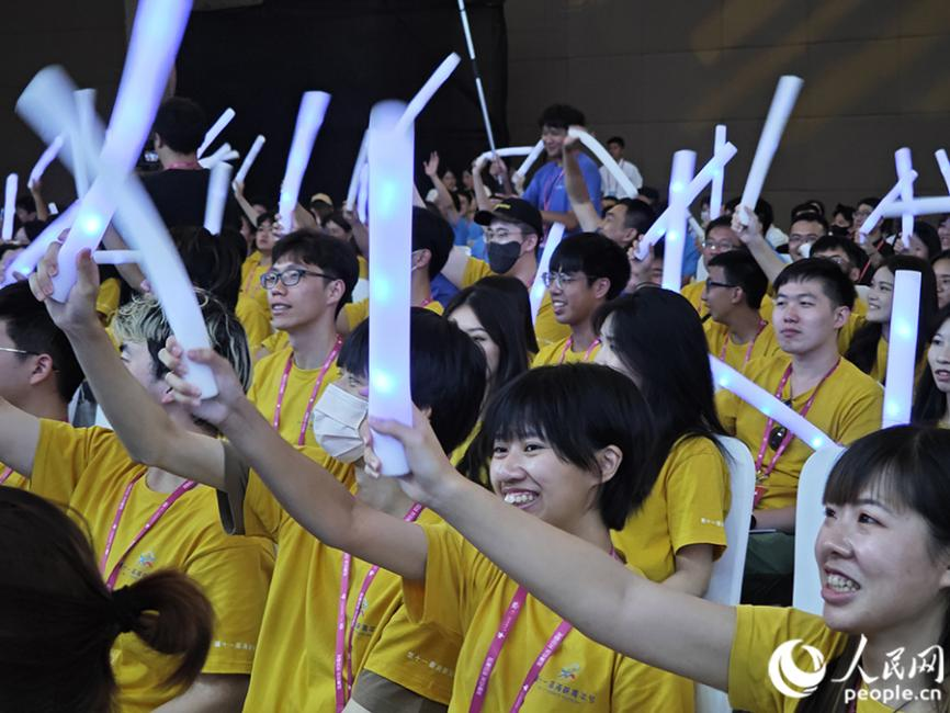 活动现场气氛热烈，台下的青年代表们热情地挥舞手中的荧光棒。人民网 黄东仪摄