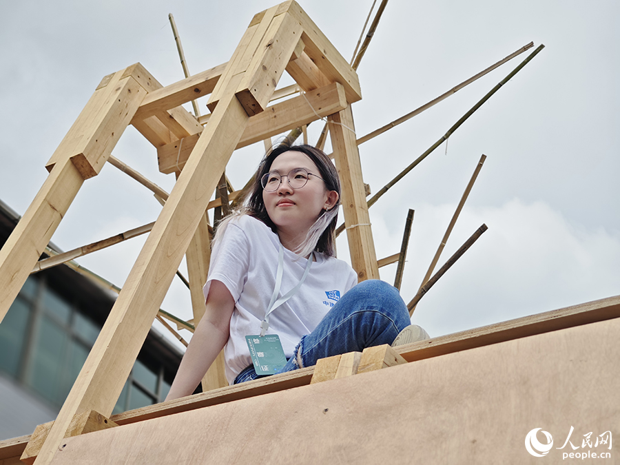 8月9日，“中建海峡杯”第十届海峡两岸大学生实体建构大赛现场，铭传大学建筑系的吴函恩同学坐在自己亲手搭建的作品顶部眺望远处。人民网 黄东仪摄