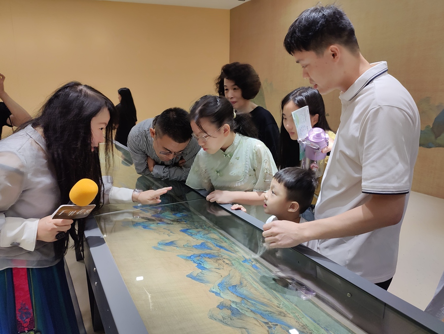 游客欣赏长卷并聆听导赏讲解。中建海峡供图