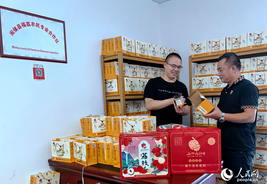 陈点成（左）和林世文（右）正在拆验新上市的荔枝蜜成品。人民网 叶青卿摄