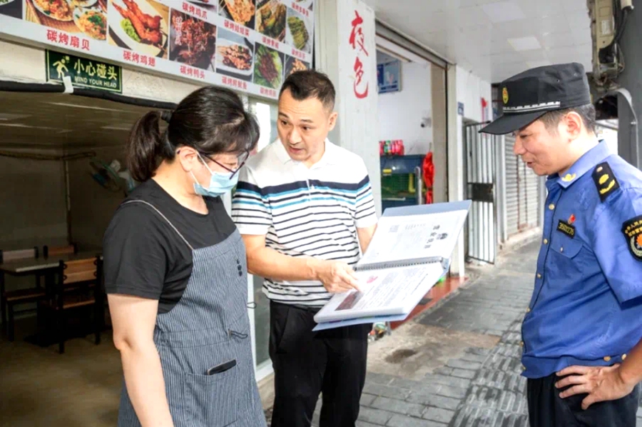 城管工作人员进店开展政策、制度宣导。思明区城管局供图