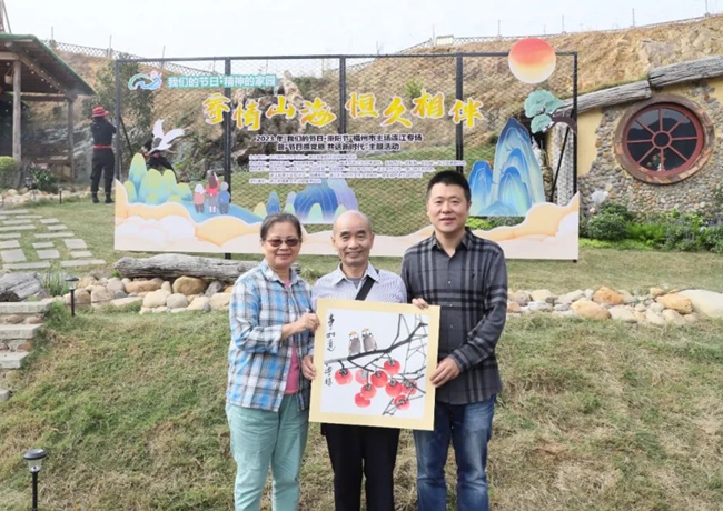 連江縣政協常委、連江縣對台藝術文化交流協會會長姚興福為黃世民夫婦獻畫，送上祝福。連江縣委文明辦供圖