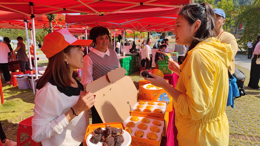 市民游客在集市上选购柿子及相关产品。古田县融媒体中心供图