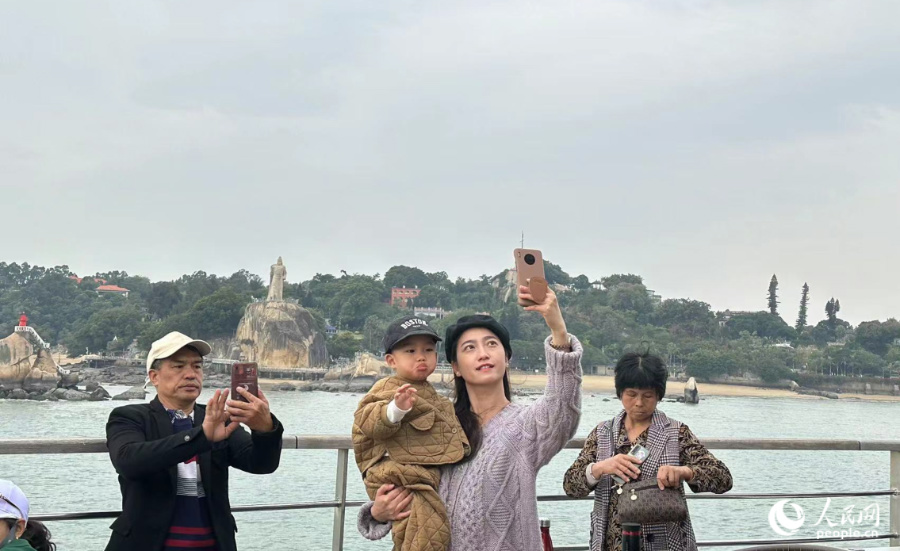 行至海上，“体验官”们纷纷掏出手机，与郑成功雕像合影。人民网记者 张萌摄