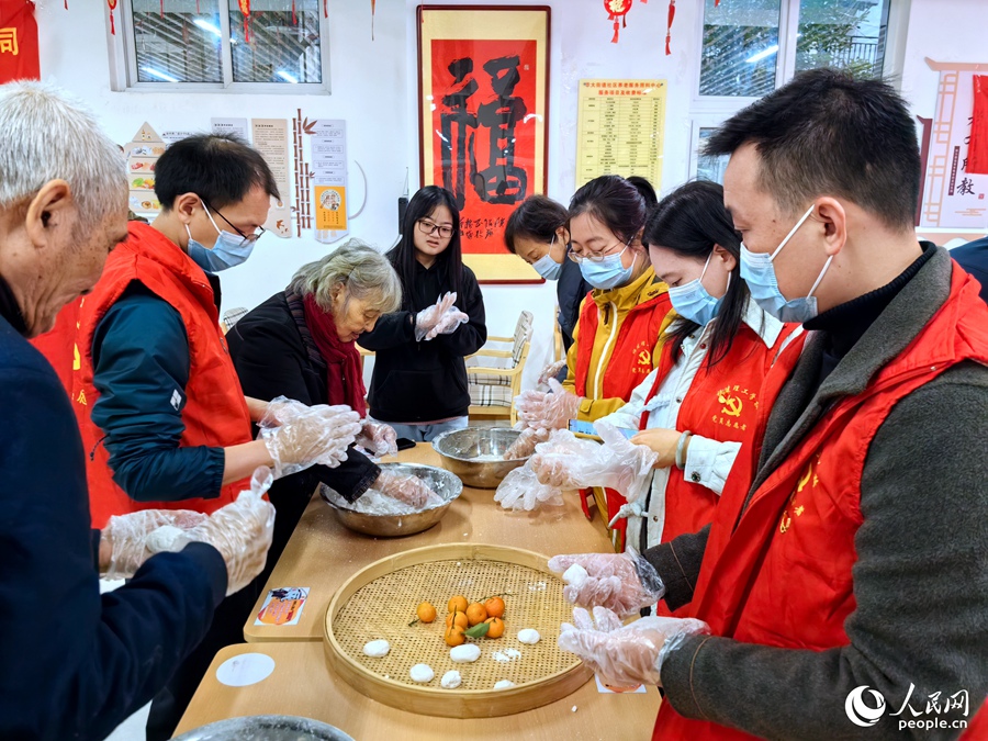 在福州市鼓楼区屏东社区长者食堂，老人们正在教年轻人搓芝麻糍。人民网 叶青卿摄