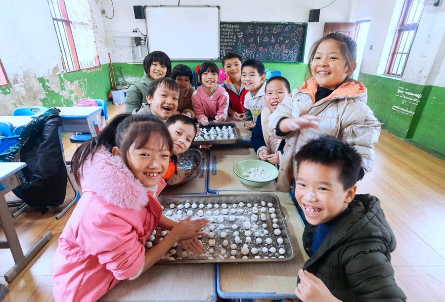 在莆田市仙游县龙华新峰小学，孩子们挽起袖子动手包汤圆。胡昂摄