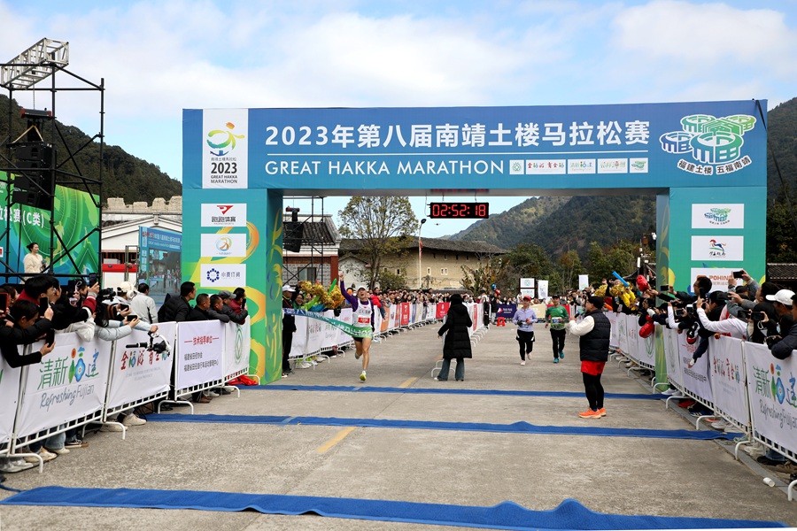 7.参赛者跑过终点，身后则是古朴土楼。杨新栋摄