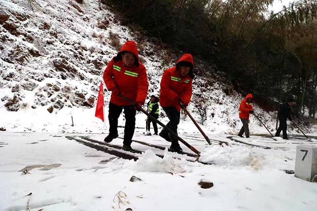 1月22日，受寒潮影响，三明市泰宁县新桥平垌山路段出现道路积雪，当地公路养护人员撒布融雪剂进行清障。陈曦摄