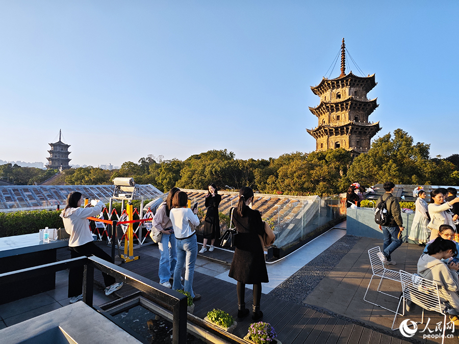 游客們在西街游客服務中心天台上與東西雙塔合影留念。人民網 黃東儀攝