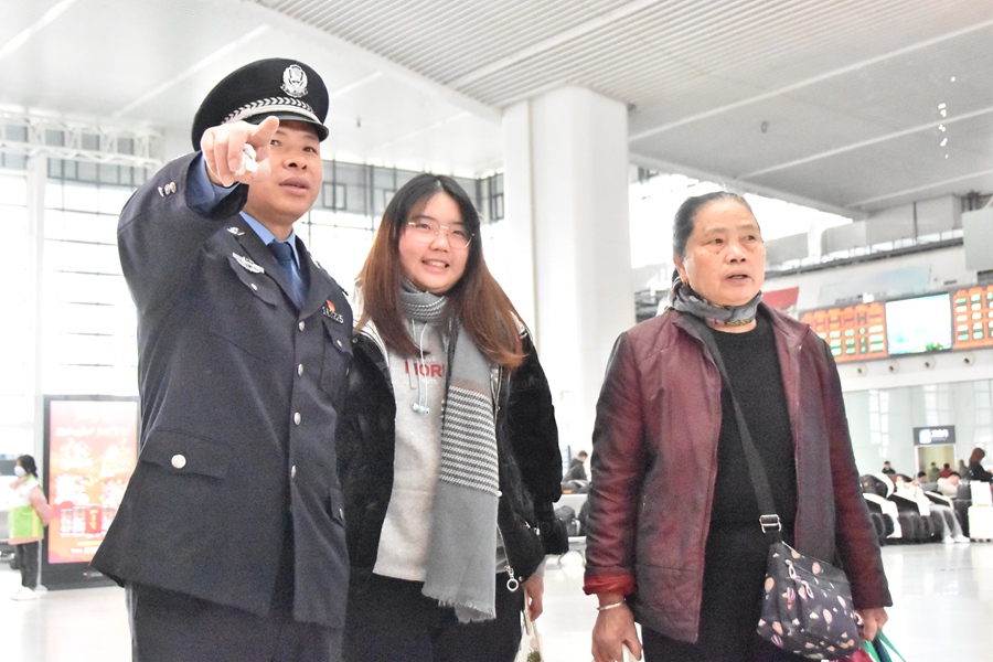 “全国人民满意的公务员”杨仁德为旅客指路。黄新景摄