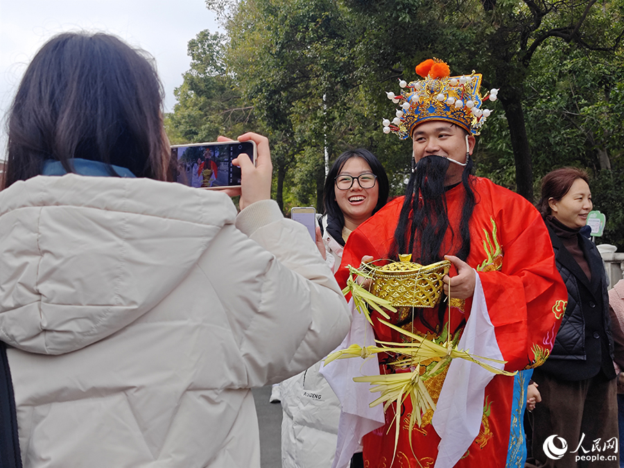 游客在西街路遇“财神爷”。人民网 黄东仪摄