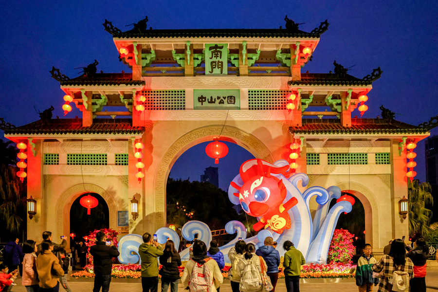 中山公園牌坊上懸挂著大紅燈籠，“福瑞龍”踏浪造型布景引人注目。楊勁堅攝