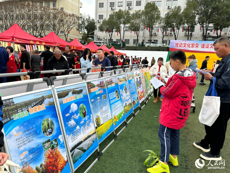 活動現場，參加有獎問答的市民正在科普展板前找答案。人民網記者 張萌攝