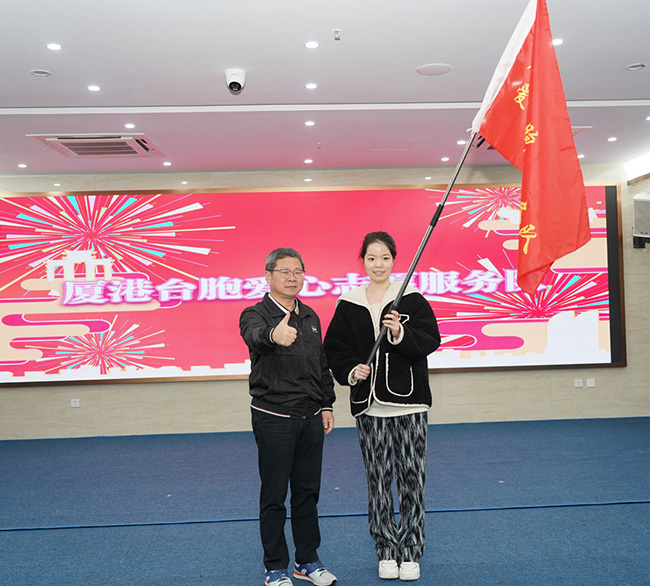 思明区人大主任吕永辉为台胞爱心志愿者服务队授旗。林林摄