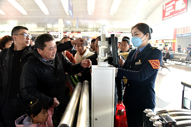 福州火车站工作人员正在帮助旅客快速检票进站乘车。江曲摄