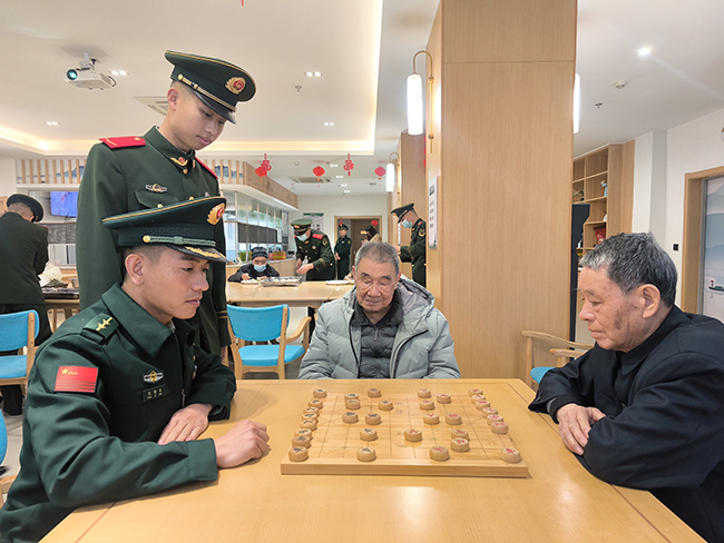 武警官兵陪老人下象棋。武警廈門支隊某中隊供圖