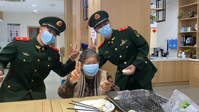 武警官兵與老人一起包餃子。武警廈門支隊某中隊供圖