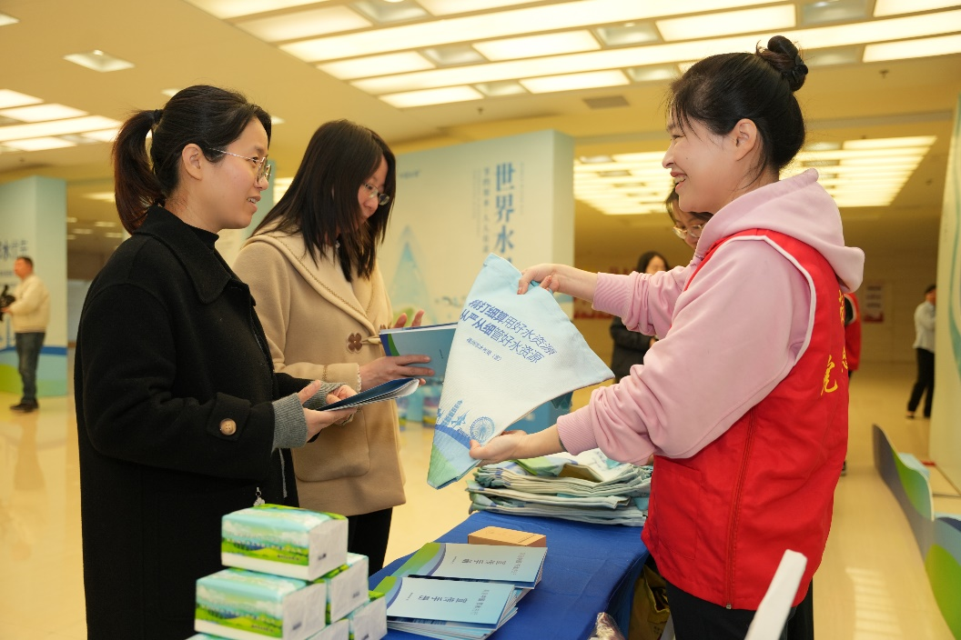 工作人员为参与者分发节水主题礼品。福州市水利局供图