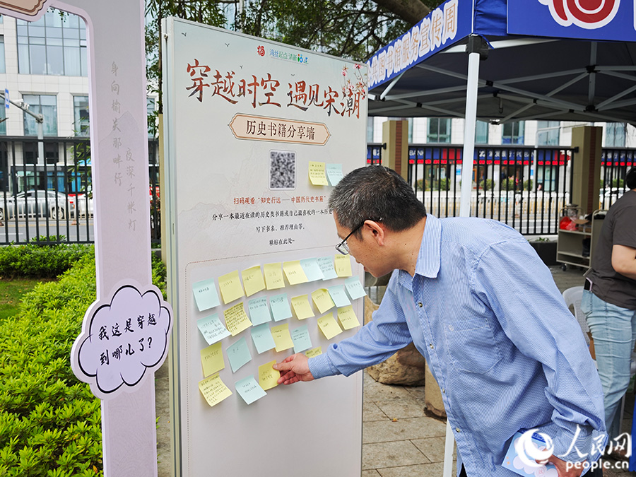 一位市民将喜爱的历史类书籍写在便利贴上，并贴上分享墙。人民网 黄东仪摄