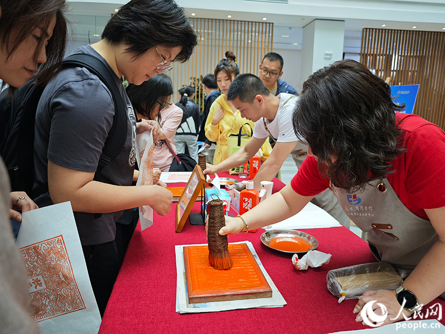 4月23日，市民在福建省图书馆体验非遗雕版印刷。人民网 黄东仪摄