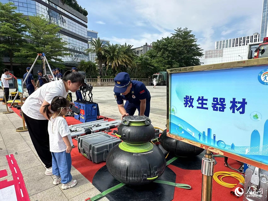活动现场，市民正在了解消防救援器材。人民网记者 张萌摄