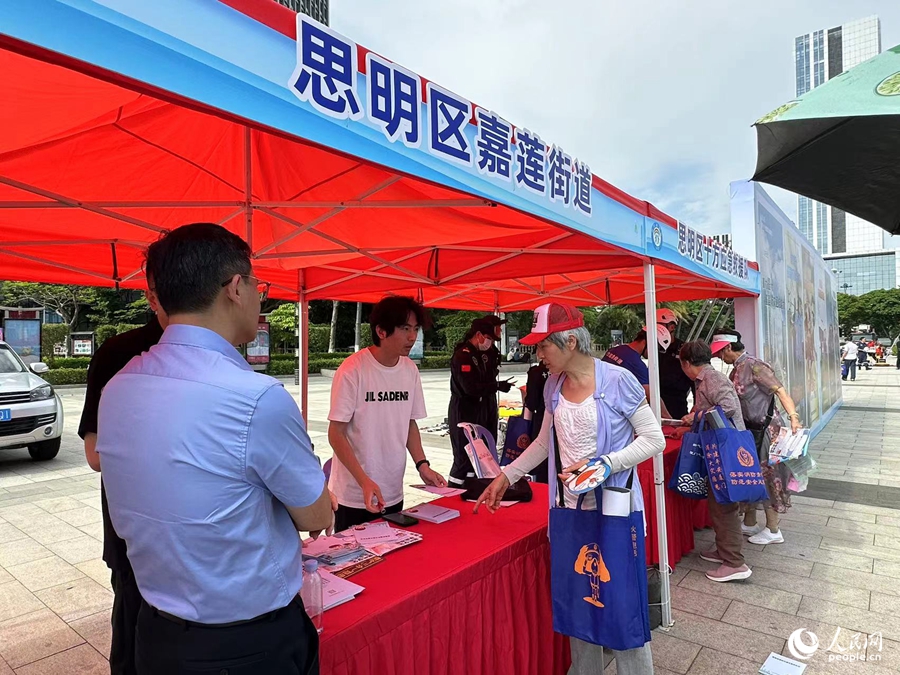 宣传展位上，工作人员向市民发放宣传材料，讲解防灾减灾救灾知识。人民网记者 张萌摄