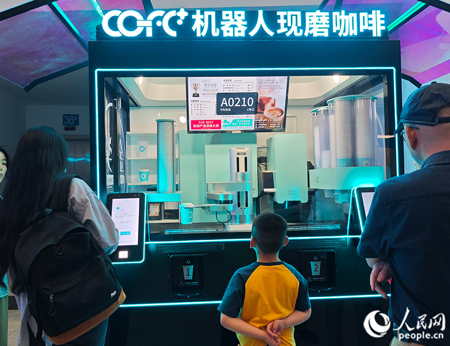 第七屆數字中國建設峰會現場體驗區內，市民等待品嘗“純機械”制作的咖啡。人民網 黃東儀攝