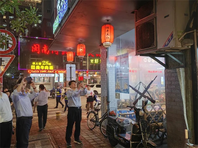 帮扶组查看记录某餐饮店面油烟管道破损情况。