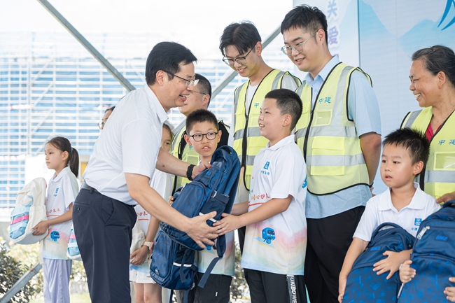 与会领导为现场留守儿童发放助学礼包。中建七局江苏公司供图