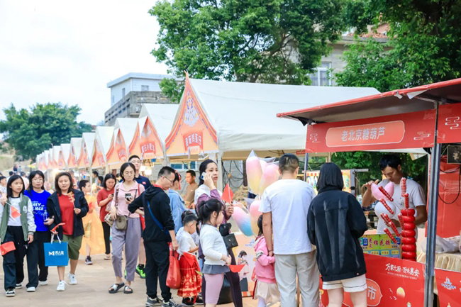 游客在摊位前选购品尝特色美食