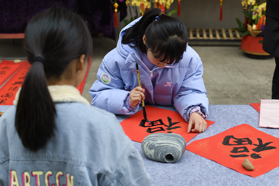 在厦门市思明区的商业街区，小朋友们自己动手写“福”字赠送给过往路人。张瑜军摄