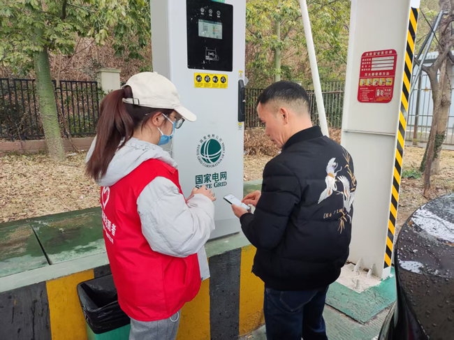 “馨”能源志願者正在充電樁前為新能源補能車主開展細心服務