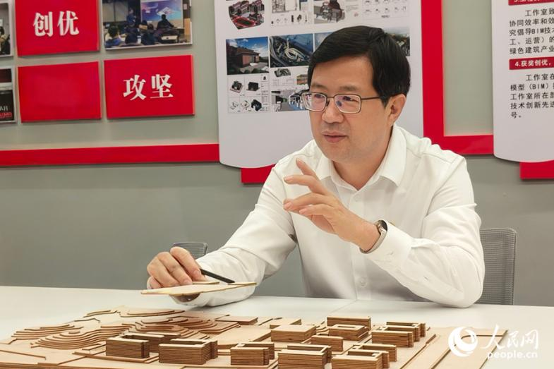 黃曉冬與團隊成員探討BIM技術。人民網 楊灝昱攝