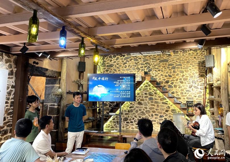 風中旅行文創工坊裡，主理人正在用歌聲歡迎遠道而來的客人。人民網記者 陳藍燕攝