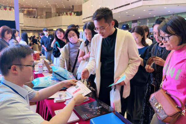 現場觀眾排隊領取集友銀行支票明信片周邊