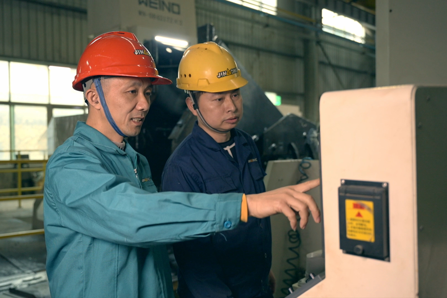 張達斌（左一）在車間指導操作。福建開放大學供圖
