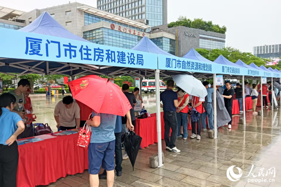 雖然大雨滂沱，但46家參與單位的工作人員依然熱情滿滿，為前來咨詢的市民群眾耐心解答問題。人民網記者 陳博攝